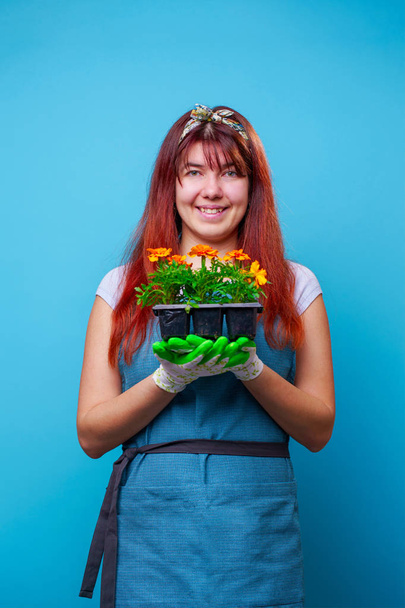 Photo of happy brunette with marigolds in her hands - Foto, Imagen