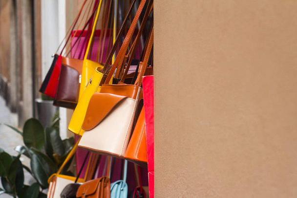 Bunte Damenhandtaschen-Handtaschen hängen an Ladenfront - Foto, Bild