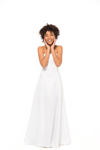 happy african american bride smiling while standing in wedding dress isolated on white  - Foto, Imagem