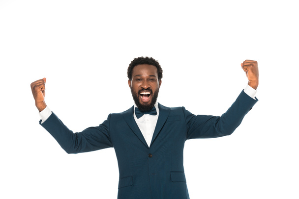 cheerful african american bridegroom gesturing while celebrating triumph isolated on white  - Fotó, kép