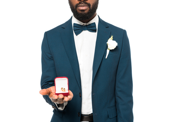白で隔離された結婚指輪を持つ箱を持つひげを生やしたアフリカ系アメリカ人男性のトリミングされたビュー  - 写真・画像