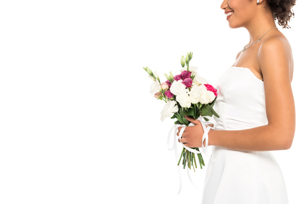 cropped view of smiling african american bride holding bouquet isolated on white  - 写真・画像
