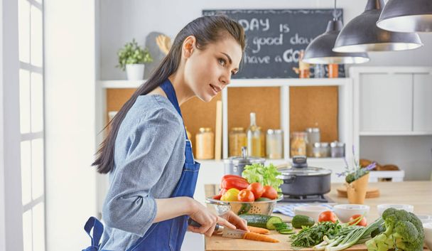 Μια νεαρή γυναίκα ετοιμάζει στην κουζίνα. Υγιεινά τρόφιμα - vege - Φωτογραφία, εικόνα