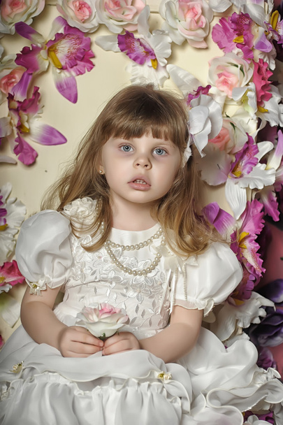 Little girl on a floral background - Φωτογραφία, εικόνα