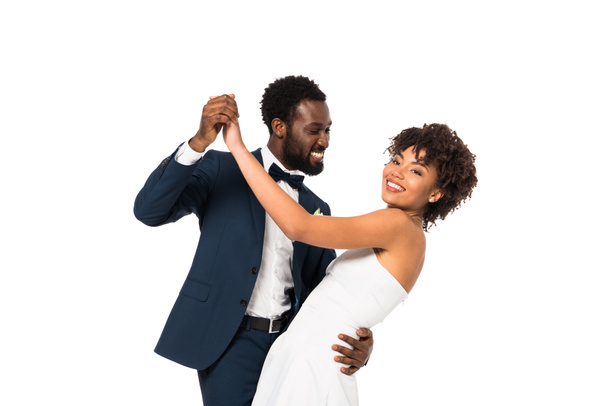 happy african american bridegroom looking at bride while dancing isolated on white  - Fotoğraf, Görsel