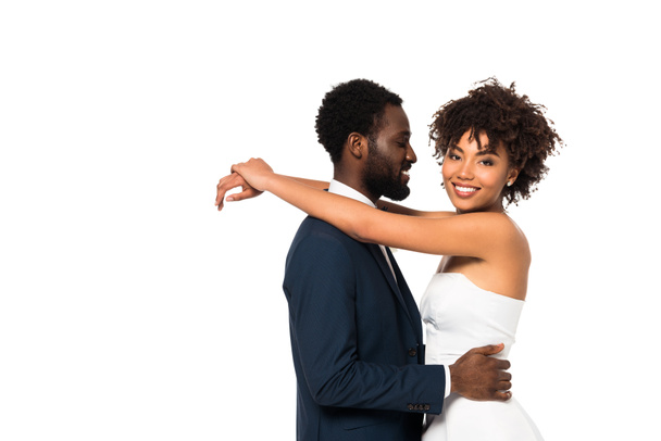 handsome african american bridegroom looking at happy bride while dancing isolated on white  - Photo, Image