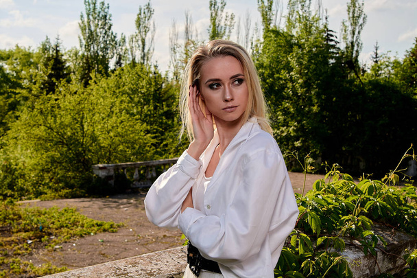 Blonde woman in the old sunny summer city park. Young woman modern portrait. - Fotografie, Obrázek