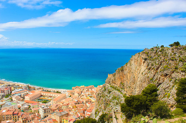 Piękny Seascape otaczającego włoskiego nadmorskiego miasta Cefalu. Piękne miasto na wybrzeżu Morza Tyrreńskiego na Sycylii jest popularnym miejscem wakacji letnich. Zaczerpniety z góry z kamieniami przylegającymi do zatoki - Zdjęcie, obraz