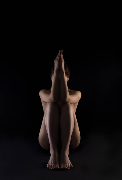 Body silhouette of naked woman, sitting on black background. - Fotoğraf, Görsel