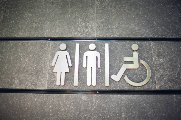 Segno di servizi igienici pubblici WC sul muro all'aperto. Per le donne, gli uomini e i disabili
 - Foto, immagini