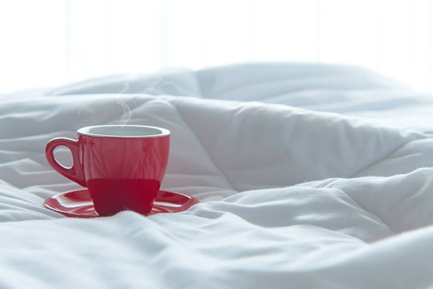 Fresh morning red cup coffee on the white bed. Lifestyle Concept - Φωτογραφία, εικόνα