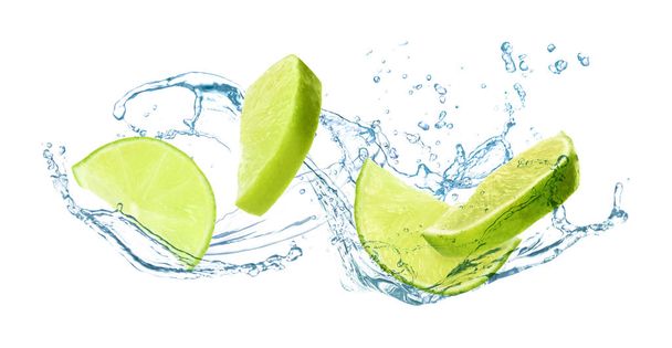 Slices of juicy lime and splashing cold water on white background - Φωτογραφία, εικόνα