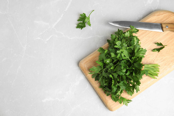 Board with fresh green parsley and knife on light background, flat lay. Space for text - Foto, immagini