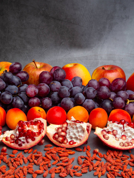mix of fresh fruits and berries, rich with resveratrol raw food ingredients. nutrition background, red fruits - Photo, Image