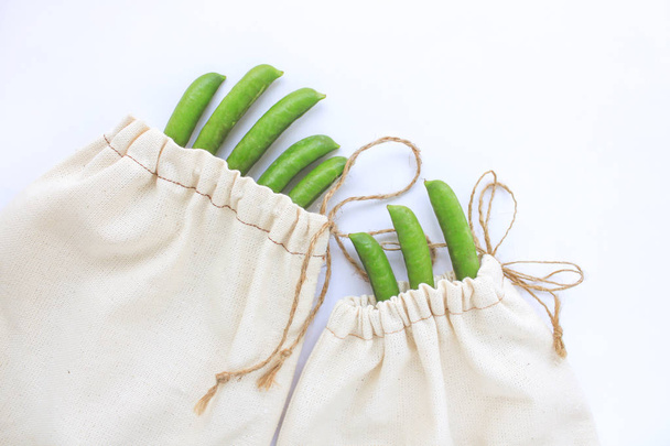 Zero waste concept, reusable cotton bags for free plastic shopping, peas, save the planet, eco style living, copy space - 写真・画像