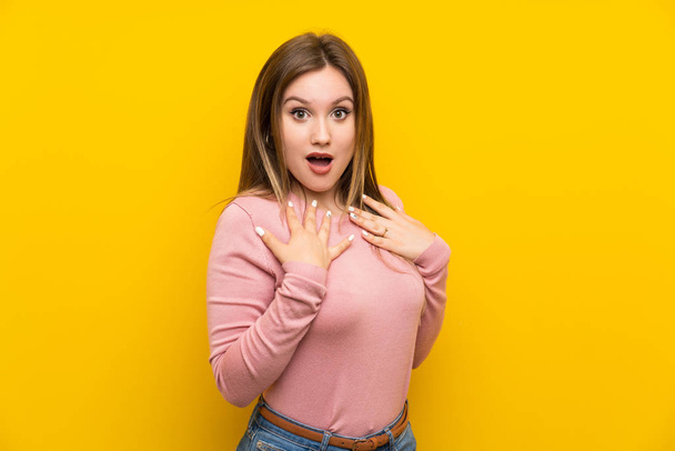 Teenager girl over isolated yellow background with surprise facial expression - Фото, изображение