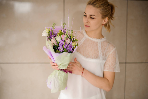 Girl holding a spring bouquet of tender violet, white and pink flowers - Fotografie, Obrázek