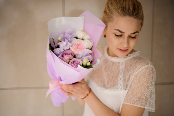 Girl holding a spring bouquet of tender violet and pink roses - Foto, afbeelding