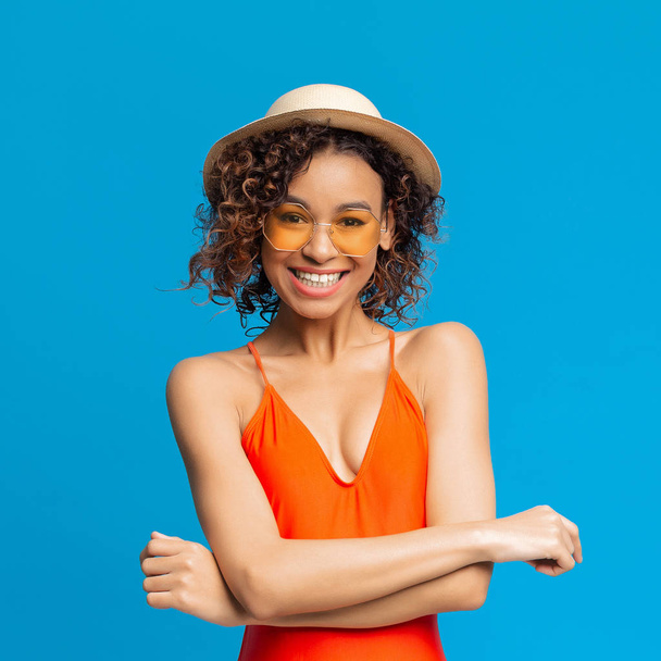 Musta millennial tyttö punainen uimapuku, paju hattu ja aurinkolasit
 - Valokuva, kuva