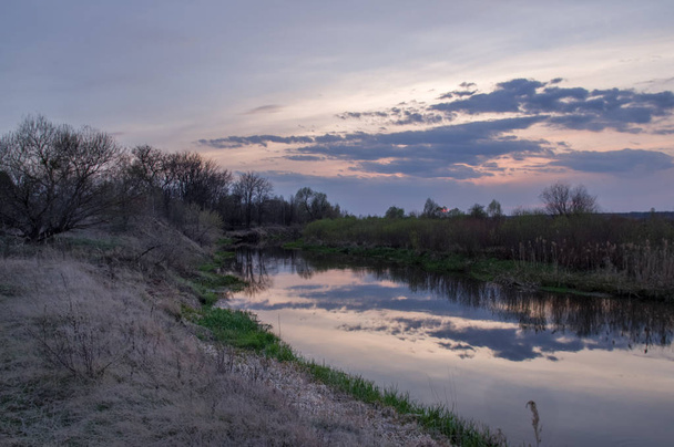 小さな川の美しい夕日。野原の夕焼け. - 写真・画像