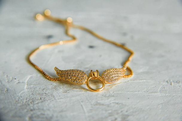Gouden hanger in de vorm van vleugels. Jeweller ornament. Hanger met edelstenen. - Foto, afbeelding