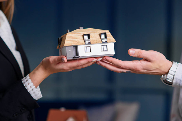 Άνθρωπος και γυναίκα χέρια κρατώντας 3D μοντέλο του σπιτιού. - Φωτογραφία, εικόνα