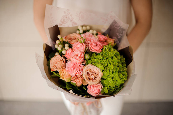 Girl holding a bouquet of tender rose color creamy and green spring flowers - Foto, immagini