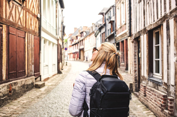 woman traveler with backpack on the streets of a quaint old town - Фото, изображение