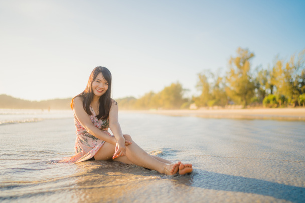 Młody Asian kobieta chodzenie na plaża Piękna kobieta szczęśliwy relaks chodzenie na plaży w pobliżu morza, gdy zachód słońca wieczorem. Lifestyle kobiet podróży na plaży koncepcji. - Zdjęcie, obraz
