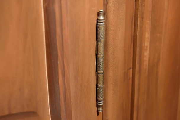 Demir kapı menteşesi. Kapının montaj yapısı. Kapının dokusu ahşaptan yapılmıştır. - Fotoğraf, Görsel