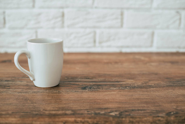 weiße Tasse auf einem Holztisch - Foto, Bild
