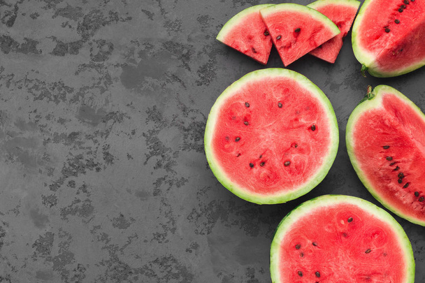 Cut fresh juicy watermelon on dark grey table - Фото, изображение