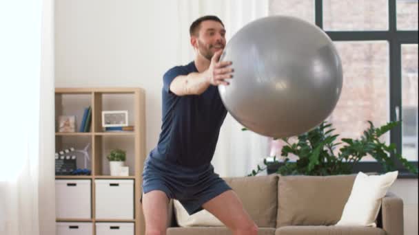 man exercising and doing squats with ball at home - Felvétel, videó