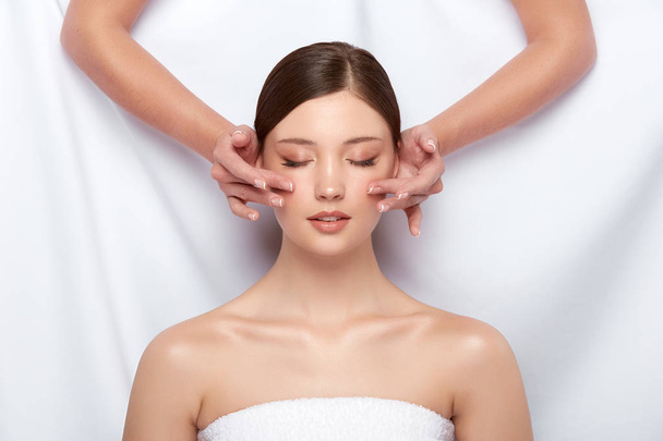 cosmetologist making massage to young woman - Fotografie, Obrázek