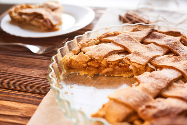 Вживання солодкої їжі. Традиційні свята яблучний пиріг, скибочки на білій тарілці та яблука. Смачні солодкі частування
 - Фото, зображення