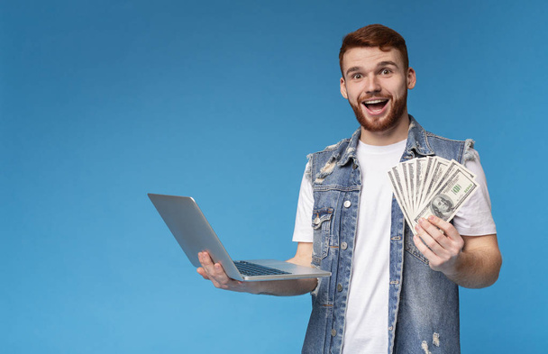Gelukkige jonge kerel wint geld op het Internet - Foto, afbeelding