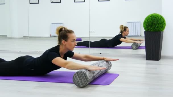 Fit mulher fazendo pilates exercícios de reabilitação com rolo e tapete de ioga
. - Filmagem, Vídeo