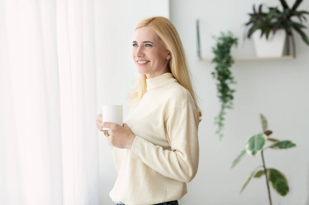 Morning Coffee. Mature Woman Looking Over Window - Photo, Image