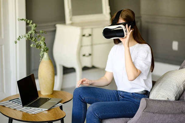 young woman uses virtual reality glasses in beautiful flat - Фото, изображение