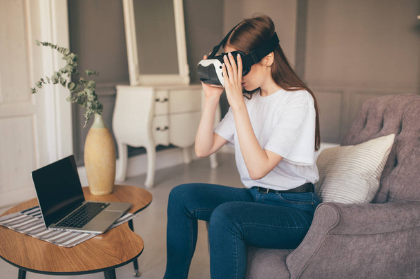 Young female programmer testing a new app with virtual reality glasses in home - Fotografie, Obrázek