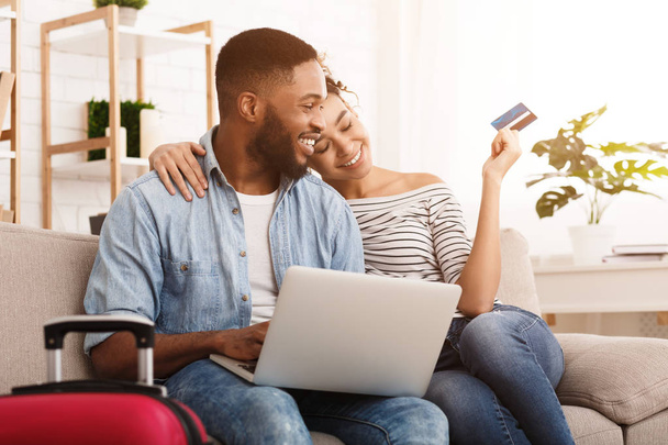 Booking Tour. African-American Couple Using Laptop At Home - Fotó, kép