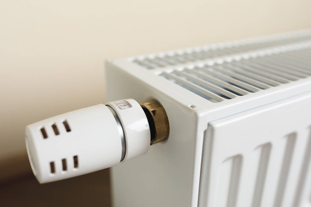 radiador de aquecimento com botão termostático na sala de estar
 - Foto, Imagem