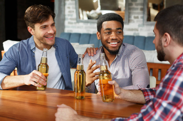 Mejores amigos conociendo y bebiendo cerveza en el bar
 - Foto, Imagen