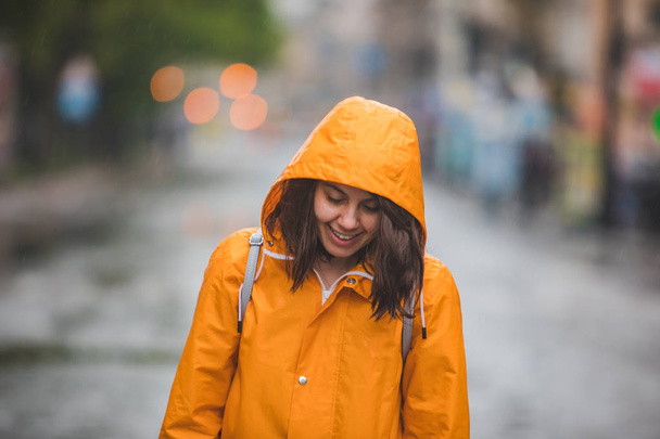 fiatal szép mosolygó nő portré esőkabát kapucnival - Fotó, kép