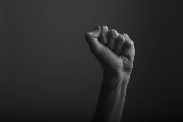 Raised clenched fist against a dark background, power, protest concept - Fotoğraf, Görsel