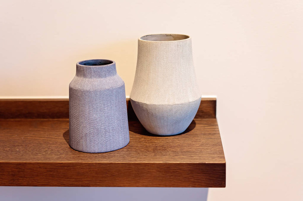 vasos de cerâmica simples contra uma parede lisa
 - Foto, Imagem