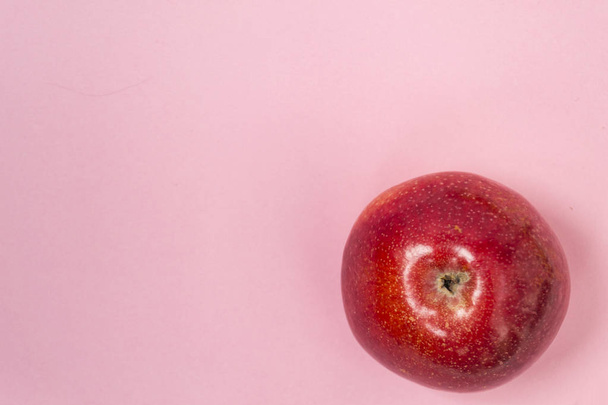 Fresh red apple on a plain pink background. Healthy food concept. - Fotografie, Obrázek