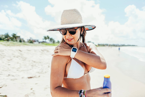 Sunscreen, sunblock. Woman putting solar cream on shoulder smiling beautiful summer day. Skincare. Girl applying sun cream - Фото, изображение