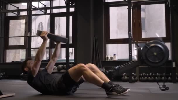Крупним планом стрілянина для дорослих м'язистий спортсмен гойдається прес і підйомні ваги в приміщенні спортзалу
 - Кадри, відео