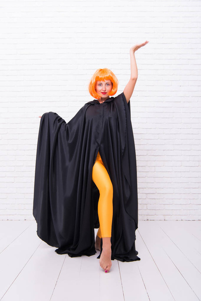 Stop hiding bright energy. Feel your body. Dancing theatre performer. Girl with long fit legs orange tights dancing. Woman ginger wig performing modern art dance. Dancer lifestyle. Dancing in cloak - Photo, image
